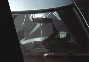 foto van een bestuurder met zijn telefoon op schoot tijdens het rijden